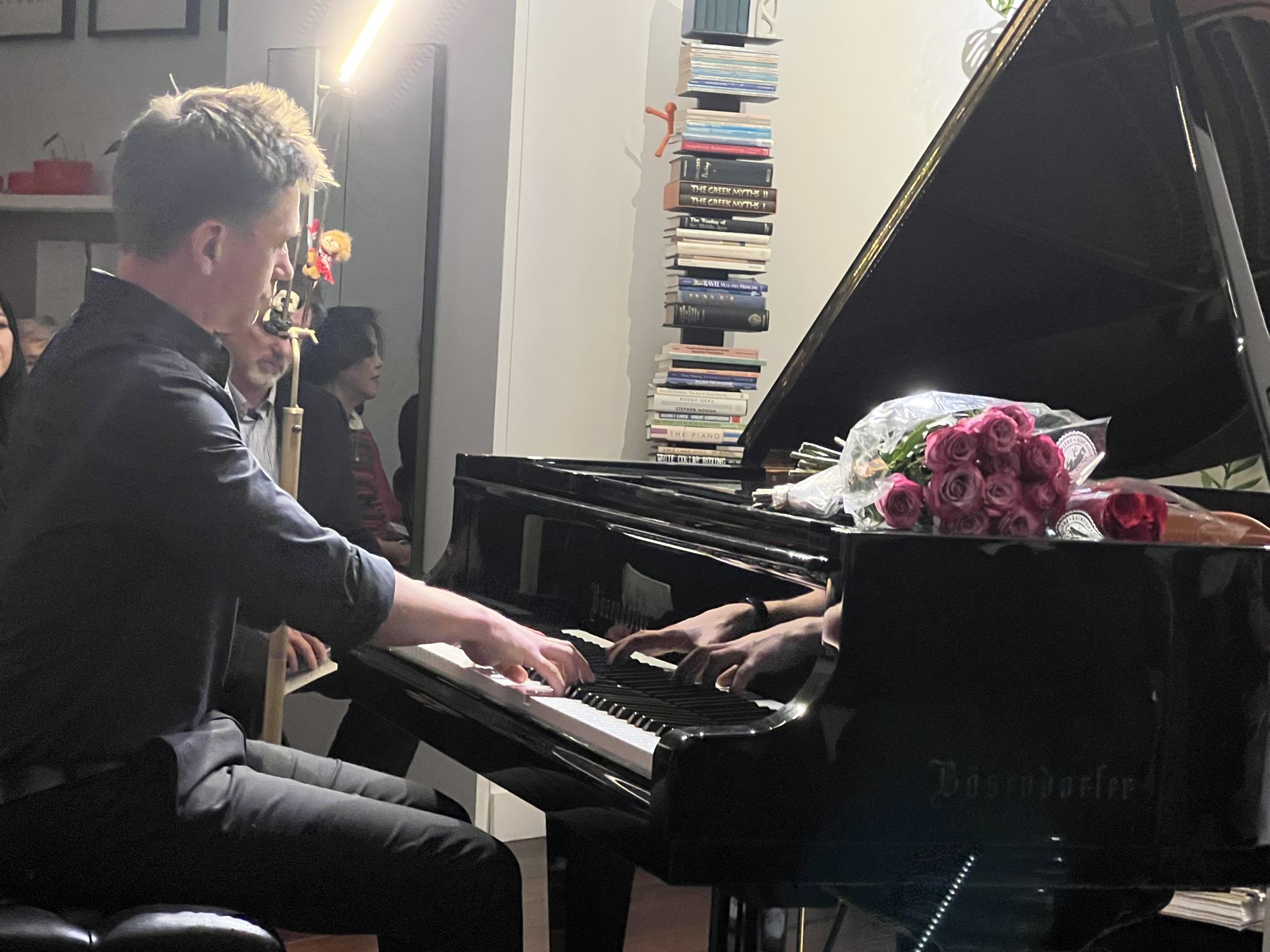 Hands, and roses on the piano